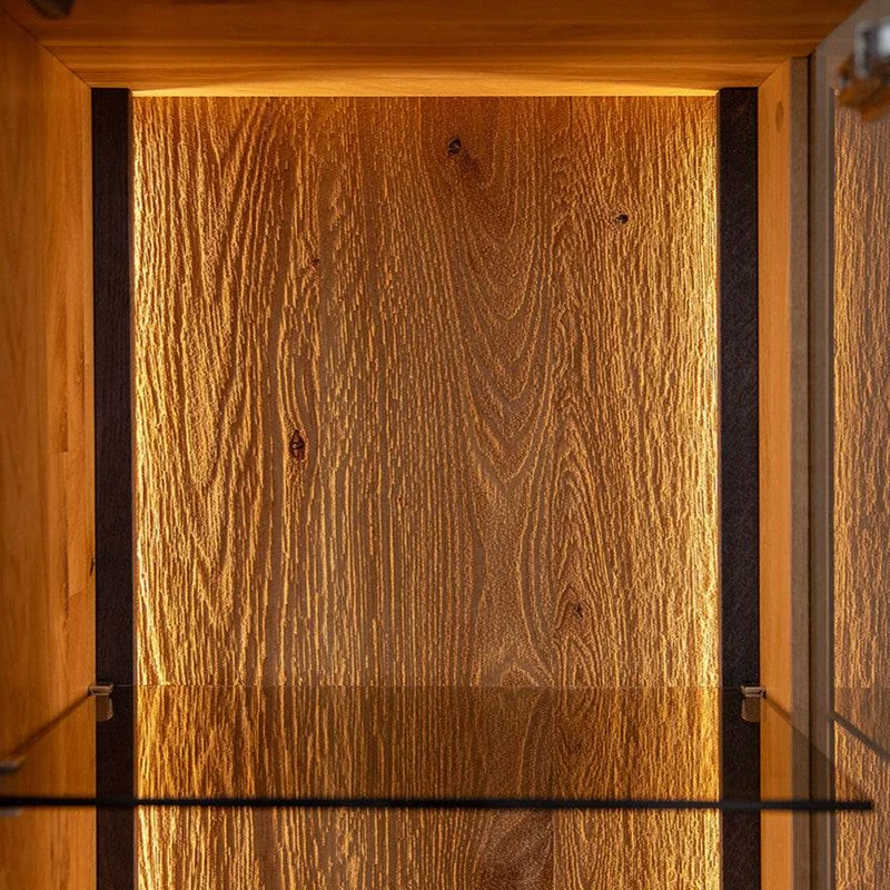 Beleuchtetes Vitrinen Sideboard Collodi aus massiver Wildeiche mit Rückwand in grober Holzstruktur