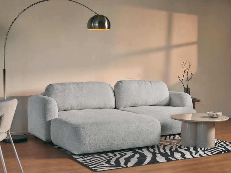 Ecksofa mit Schlaffunktion Tvoya, L-förmig, linksseitig, hellgrauer Bouclé-Stoff