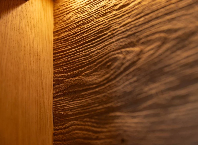 Beleuchtete Standvitrine aus massiver Eiche und Glas | Wohnzimmerschrank Tirano IV mit Rückwand in grober Holzstruktur