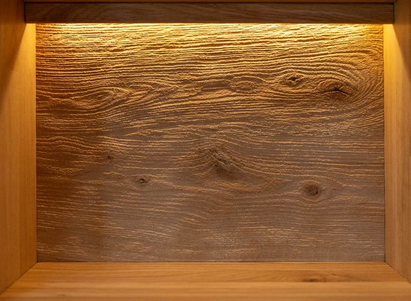 Beleuchtete Standvitrine aus massiver Eiche mit Lamellen | Wohnzimmerschrank Tirano II mit Rückwand in grober Holzstruktur