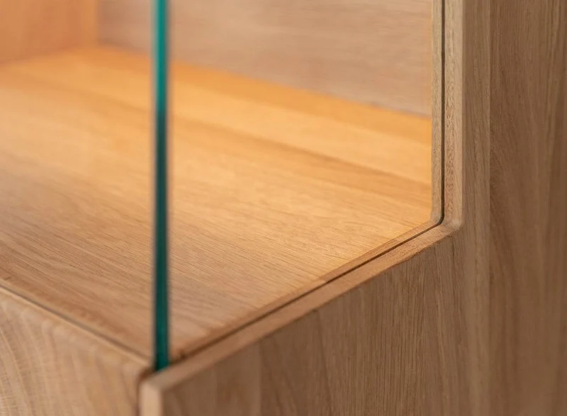 Beleuchtete Standvitrine aus massiver Eiche mit Lamellen | Vitrine Tirano II mit Rückwand in grober Holzstruktur