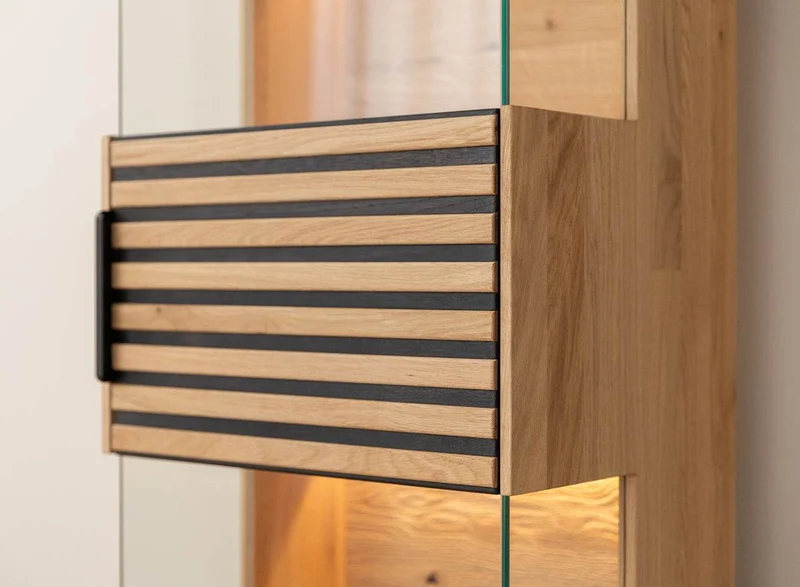 Beleuchtete Standvitrine aus massiver Eiche mit Lamellen | Vitrine Tirano II mit Rückwand in grober Holzstruktur