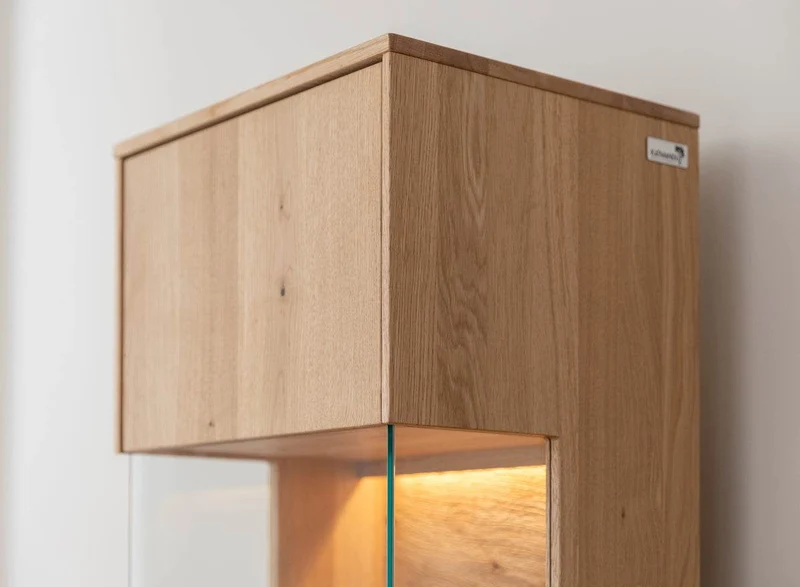 Beleuchtete Standvitrine aus massiver Eiche | Vitrine Tirano I mit Rückwand in grober Holzstruktur